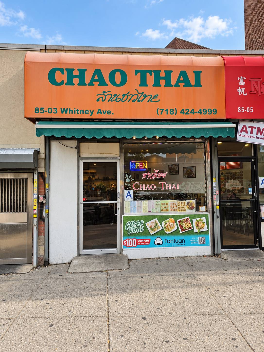 Chao Thai storefront: orange awning reading Chao Thai with the address and phone number, green awning below, entrance door on the left and the menu-lined window on the right.